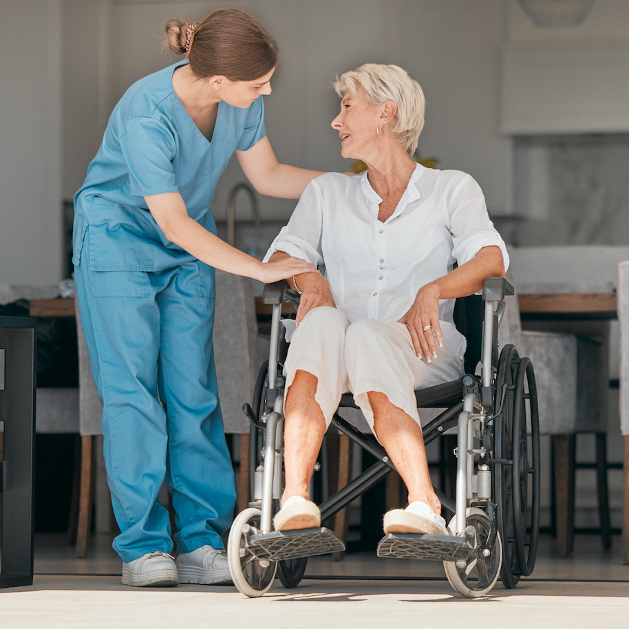Older woman in wheelchair with nurse helping at home