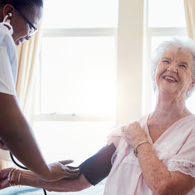 Nurse checking blood pressure of a senior woman