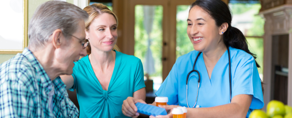 Home nurse assisting a primary caregiver with medications